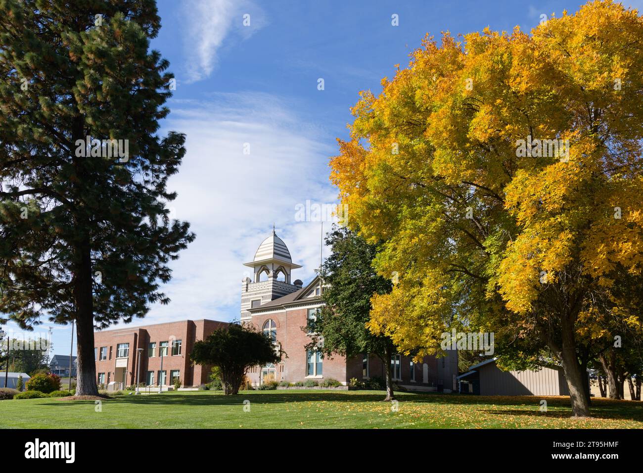 Moro, OR, USA - October 15, 2023; Sherman County Courthouse in fall in Oregon with large tree in autumnal colors Stock Photo