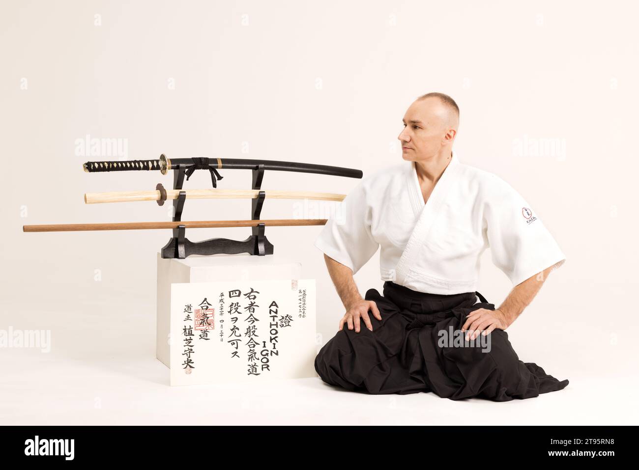 Portrait of aikido sensei master with black sensei belt in taekwondo kimono on black background. Traditional samurai hakama kimono. Healthy lifestyle Stock Photo