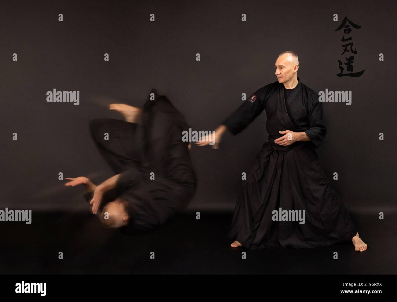 Portrait of aikido sensei master with black sensei belt in taekwondo kimono on black background. Traditional samurai hakama kimono. Healthy lifestyle Stock Photo