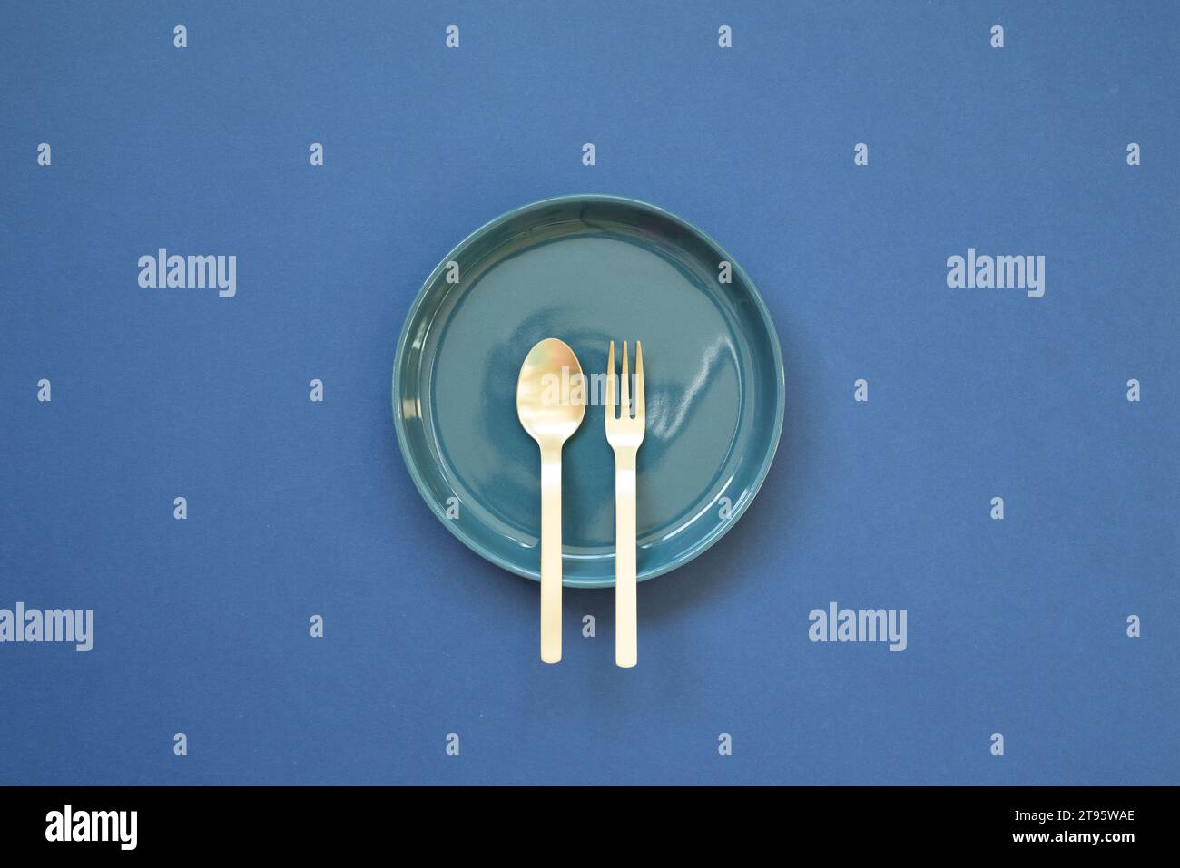 Empty plate dish with spoon, fork on navy blue background. top view Stock Photo