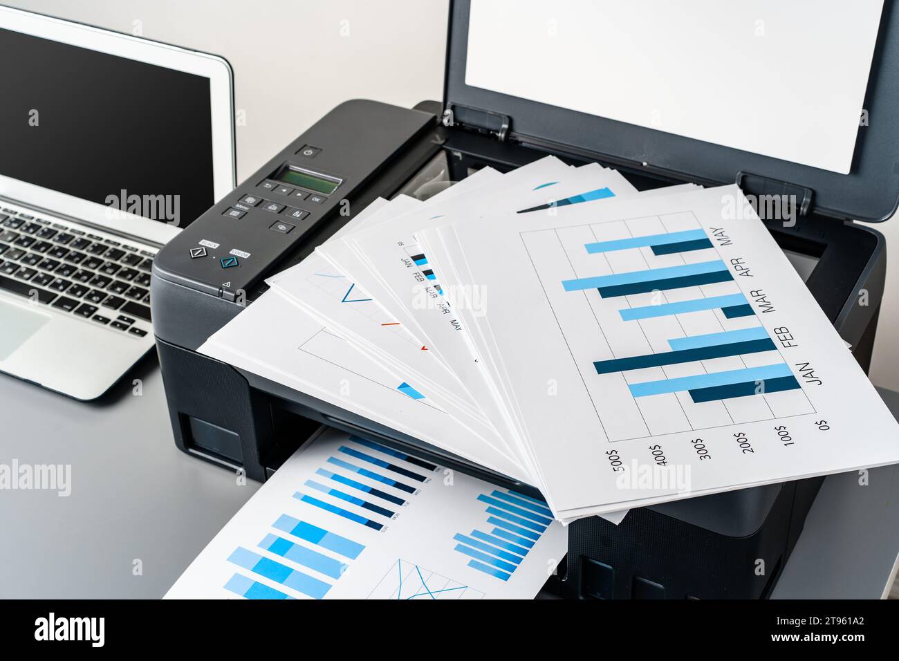 Printer and laptop on grey table in office Stock Photo