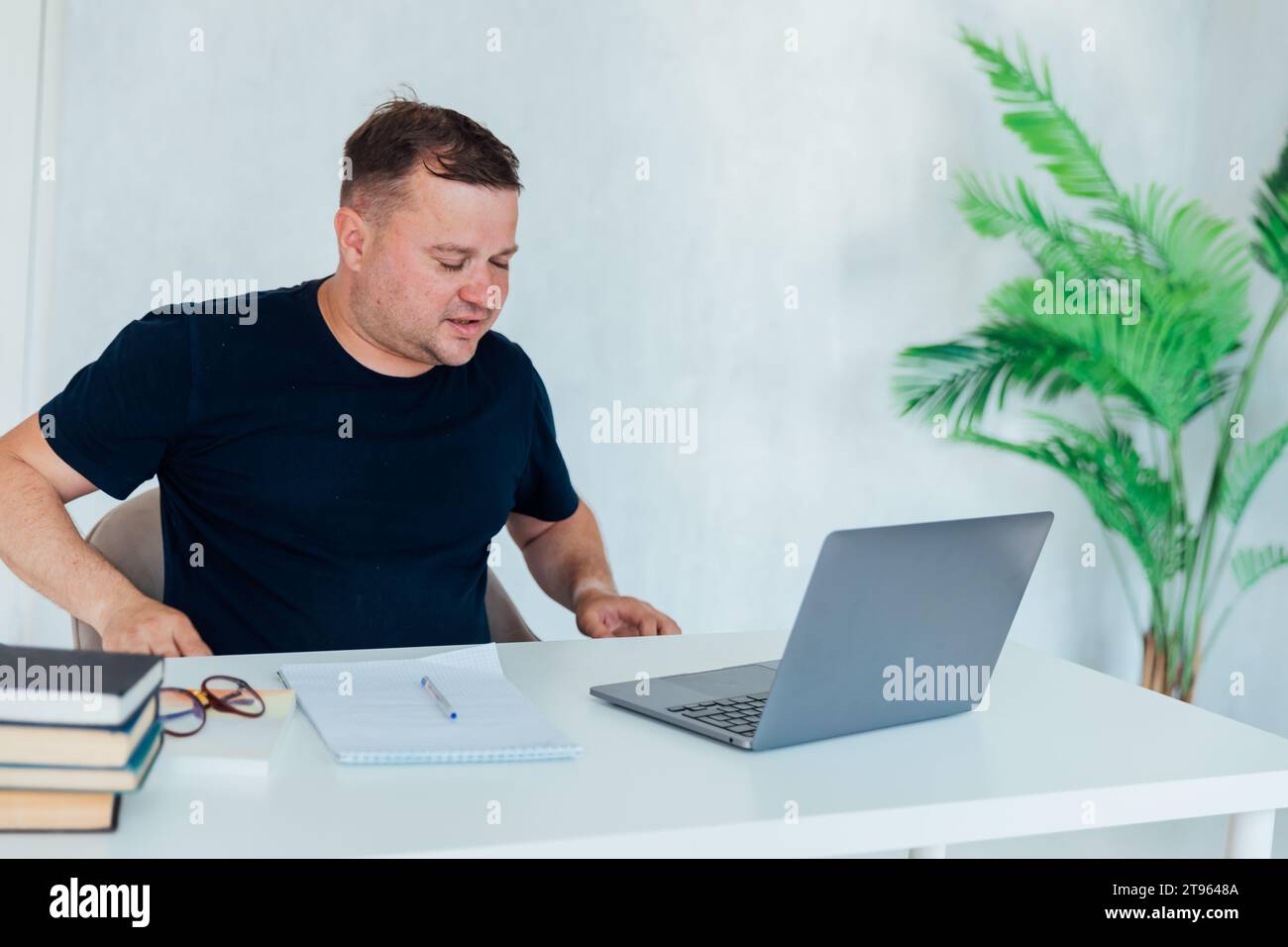 Man working on laptop in office cabinet Stock Photo