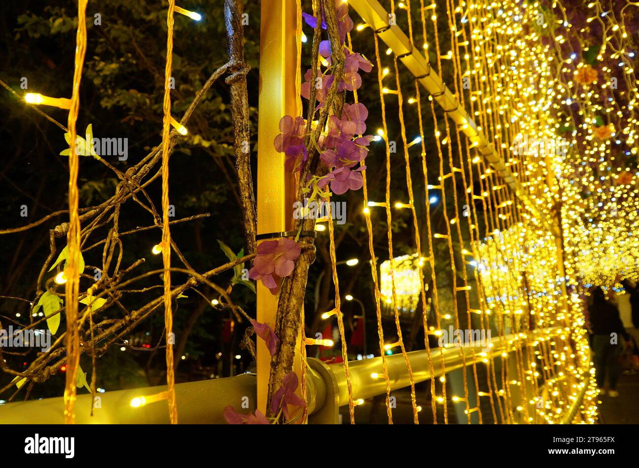 Christmas decoration on pedestrian bridge with pink cloth flowers between gold lights Stock Photo