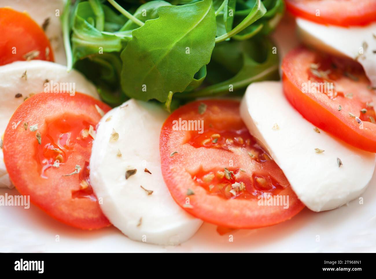 Italian salad with tomatoes and mozzarella filmed in close-up Stock Photo