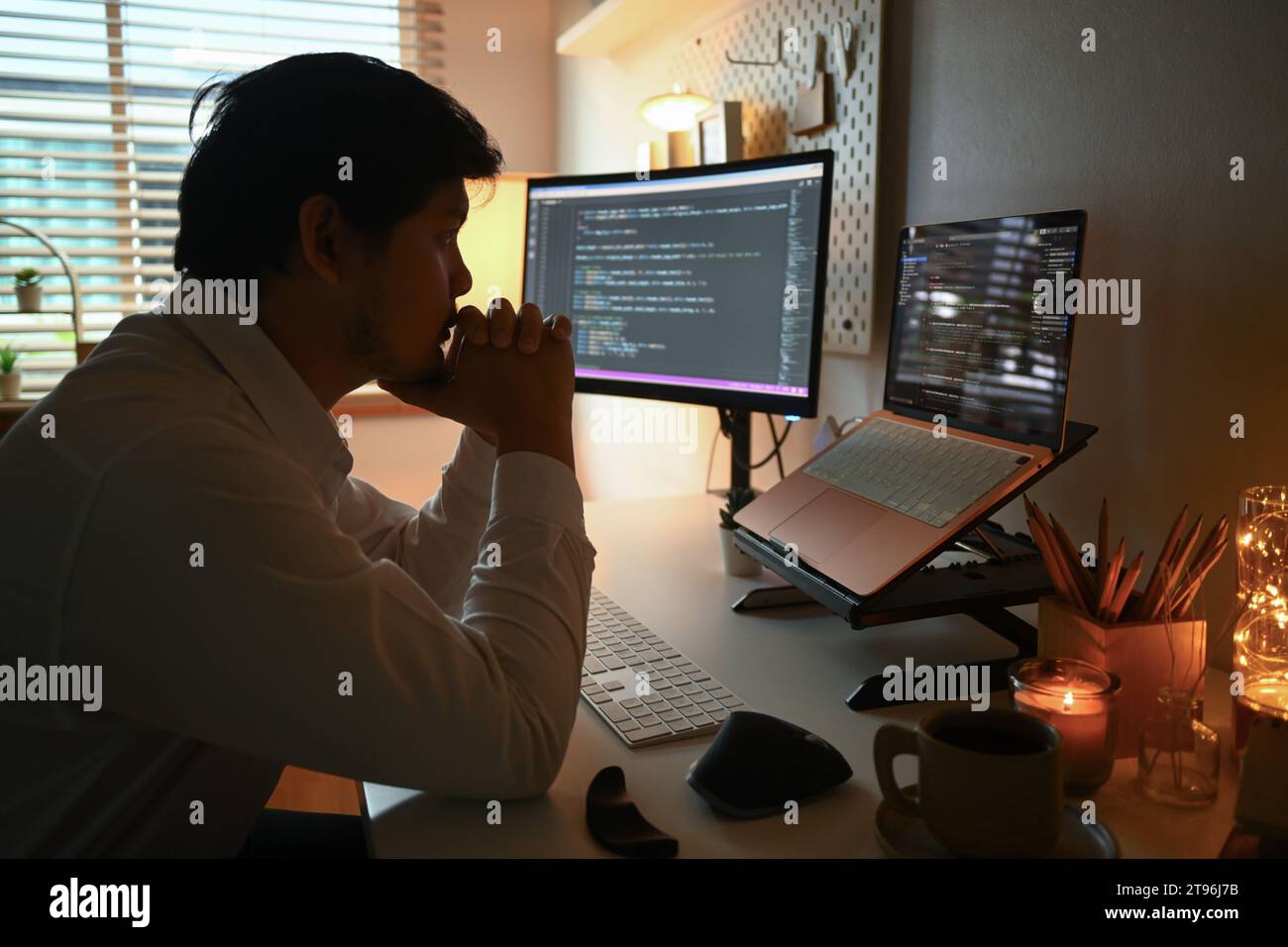 Side view of focused software developer programming on desktop computer ...
