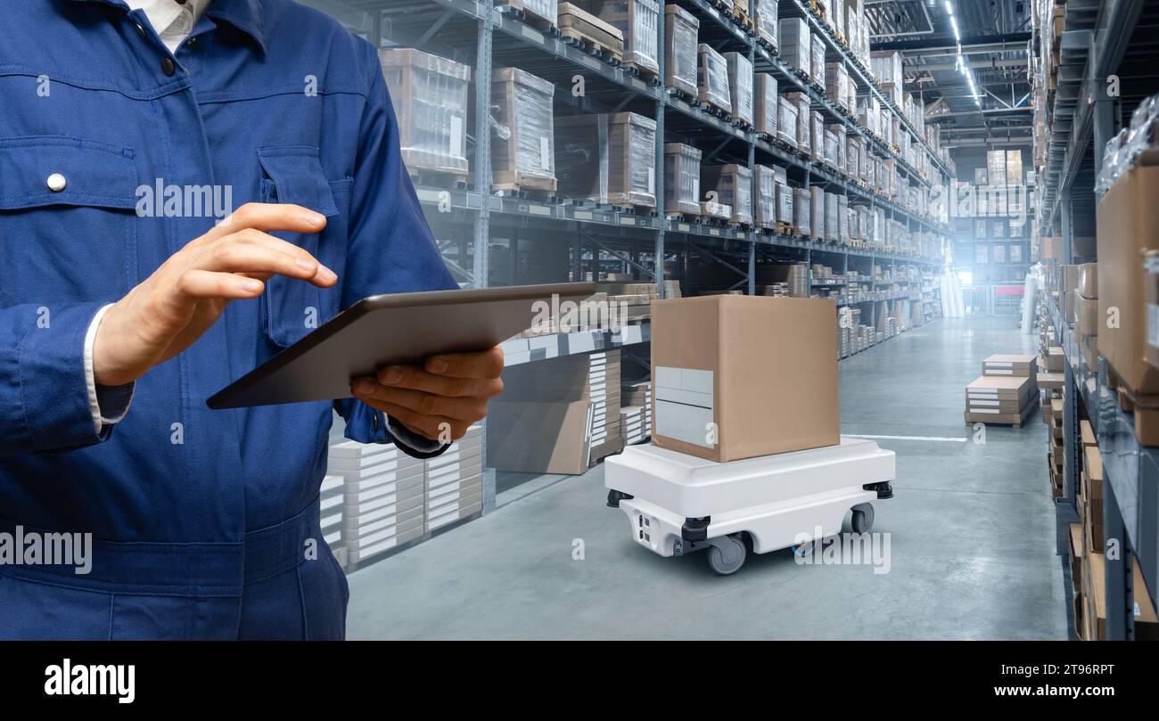 Warehouse manager with digital tablet controls robot with a package ...