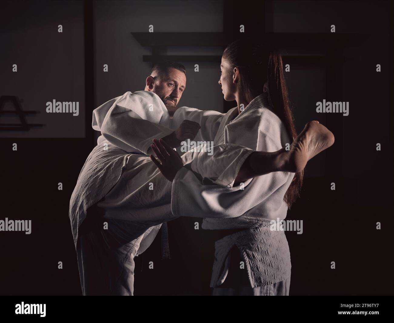 Side view of adult barefoot male punching female in white clothes