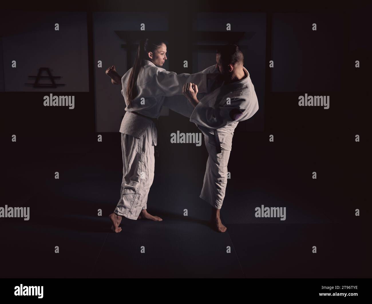 Side view of barefoot female and male in white traditional sportswear