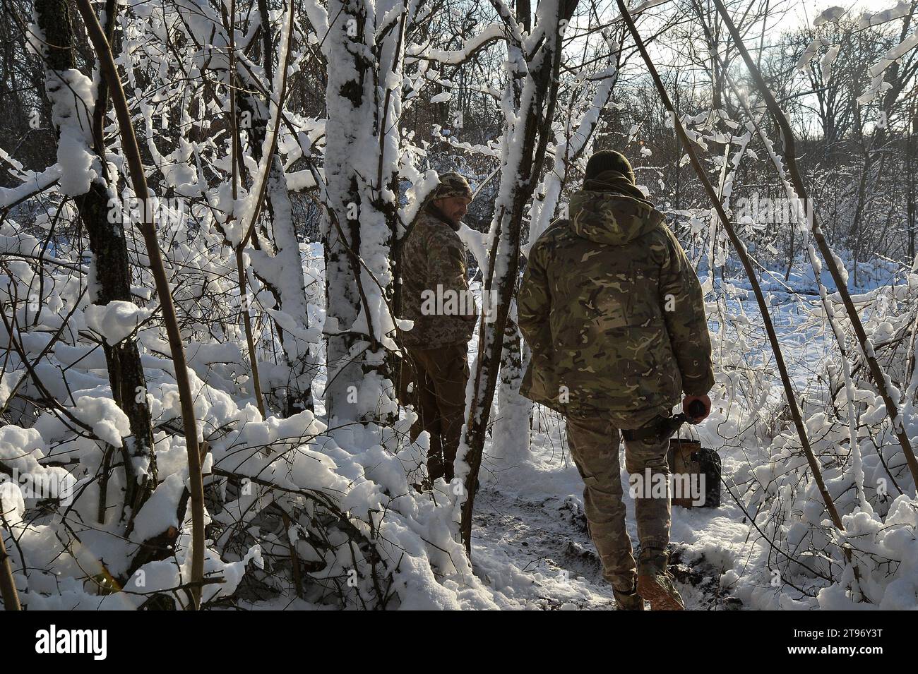 Kupyansk, Kharkiv Oblast, Ukraine. 22nd Nov, 2023. Ukrainian service members walk through the snow covered trees following a fire mission. Commanding an artillery position in the region, Ukrainian troops prepare for winter and potential Russian assaults. (Credit Image: © Madeleine Kelly/ZUMA Press Wire) EDITORIAL USAGE ONLY! Not for Commercial USAGE! Stock Photo