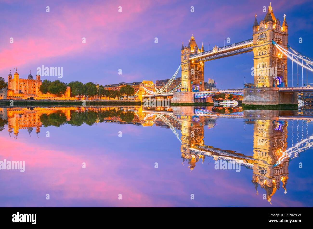 London, United Kingdom. The Tower of London and Tower Bridge reflection on river Thames, England capital spotlight, twilight illuminated scene. Stock Photo