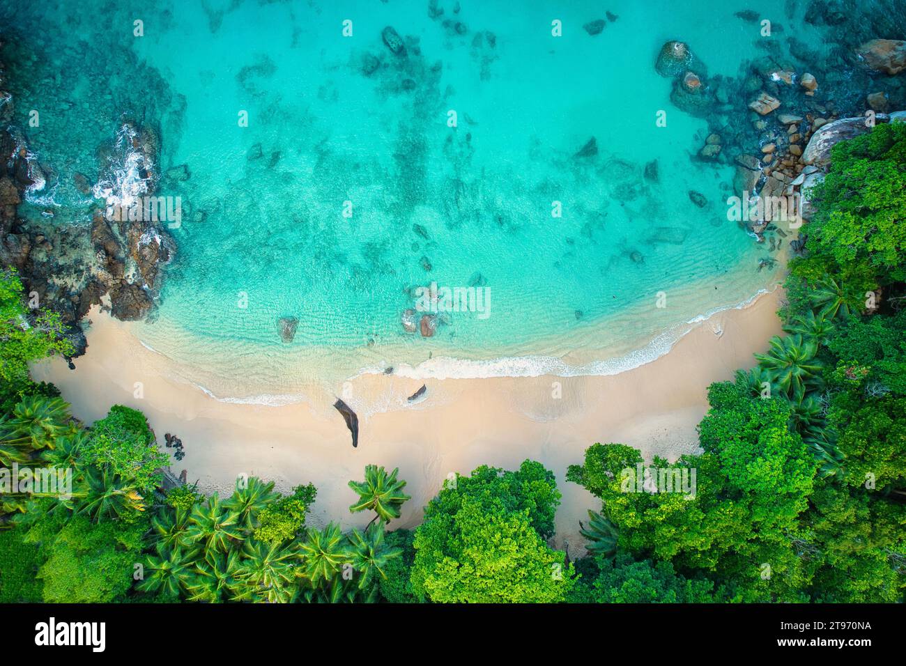 Bird eye drone photo of beautiful white sandy beach, turquoise water and granite stones, Mahe Seychelles Stock Photo