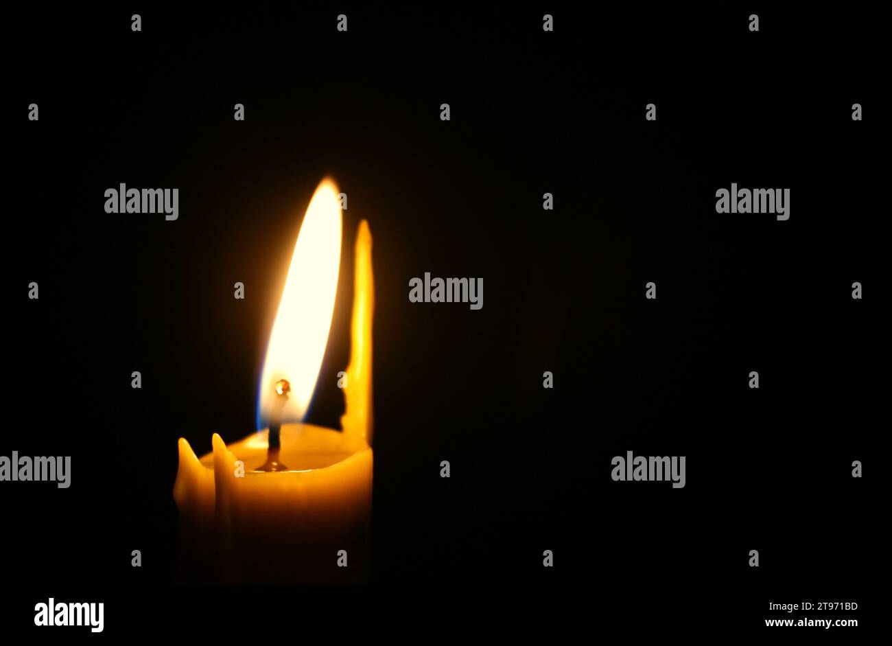 The top of a swollen candle with a staggering fire on the left side of the image. Concept for condolences card Stock Photo
