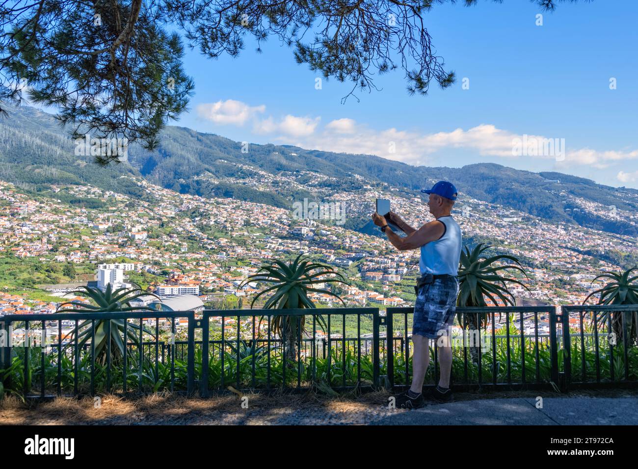 Views across Funchal Madeira from Pico dos Barcelos Viewpoint Portugal with a male tourist taking photographs Stock Photo