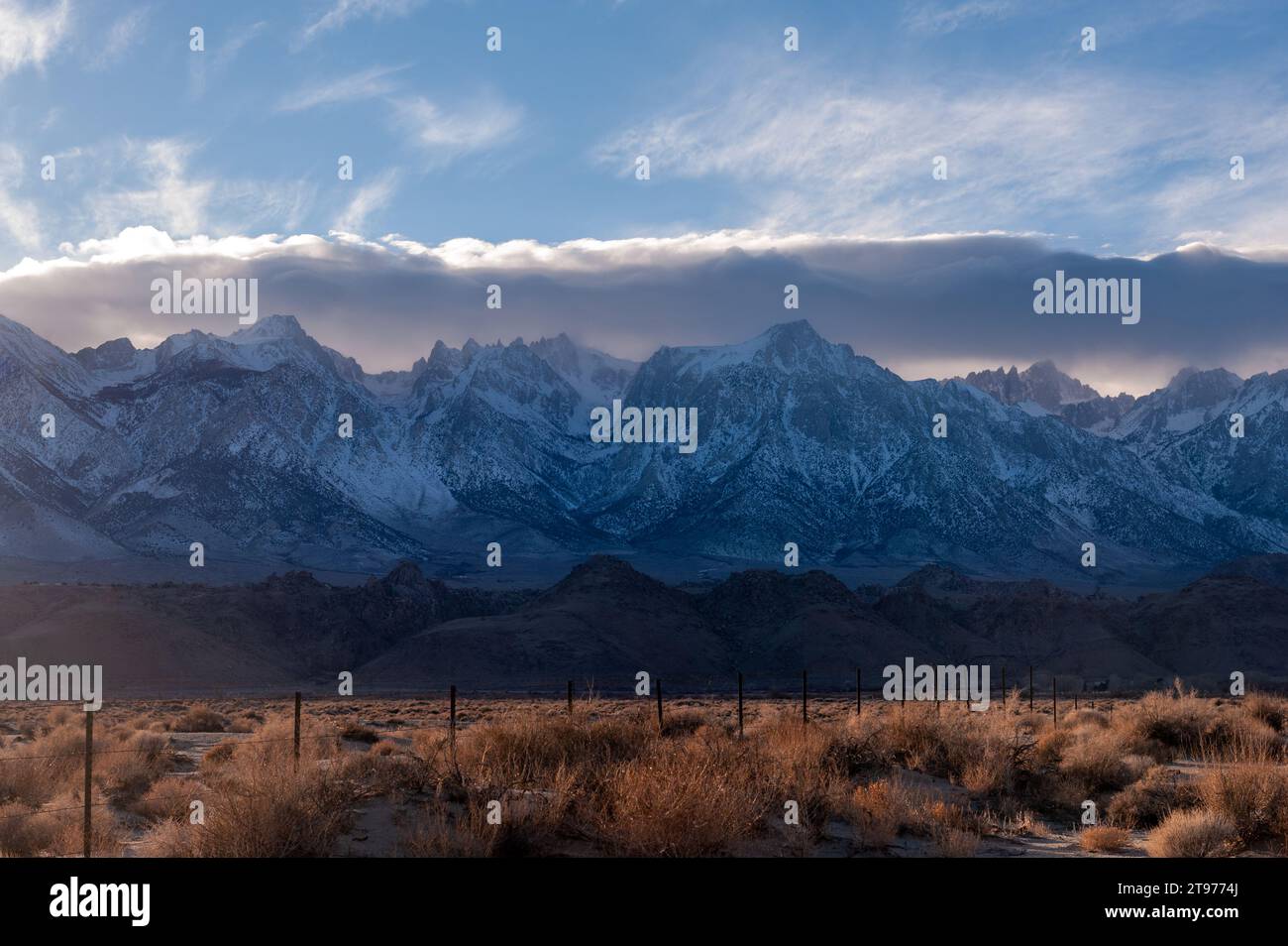 The towering mountains of the Sierra Nevada form a backdrop of the road ...