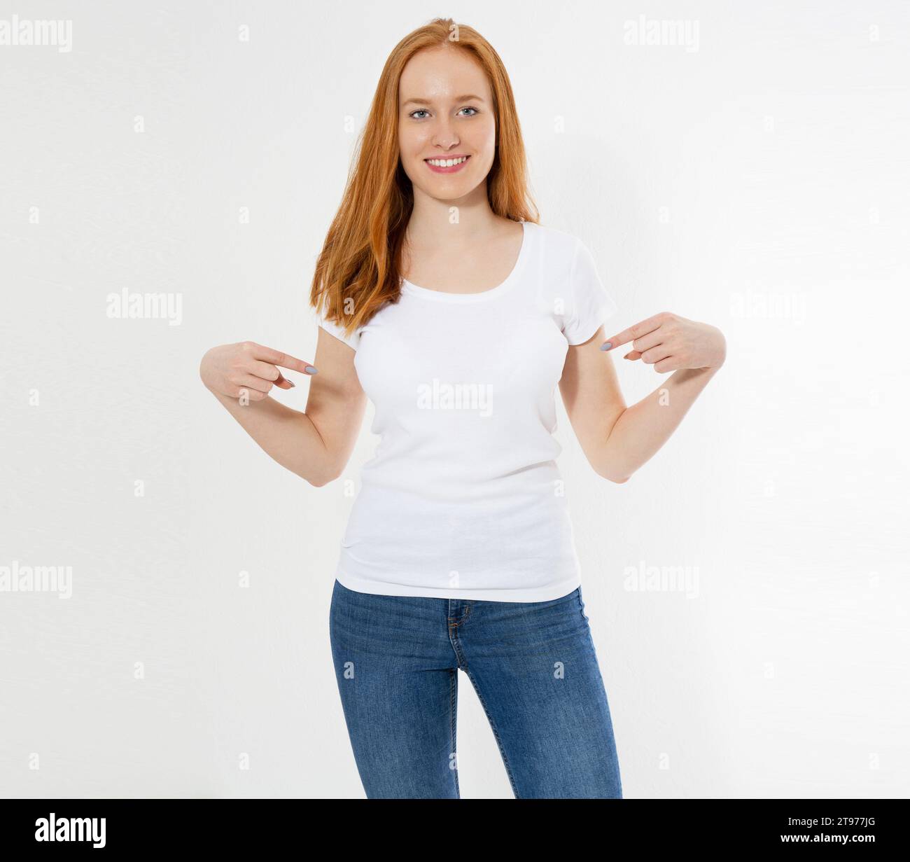 T-shirt design and advertising concept. Style and fashion. Indoor shot of cheerful smiling youngred head woman with red hair pointing index finger at Stock Photo