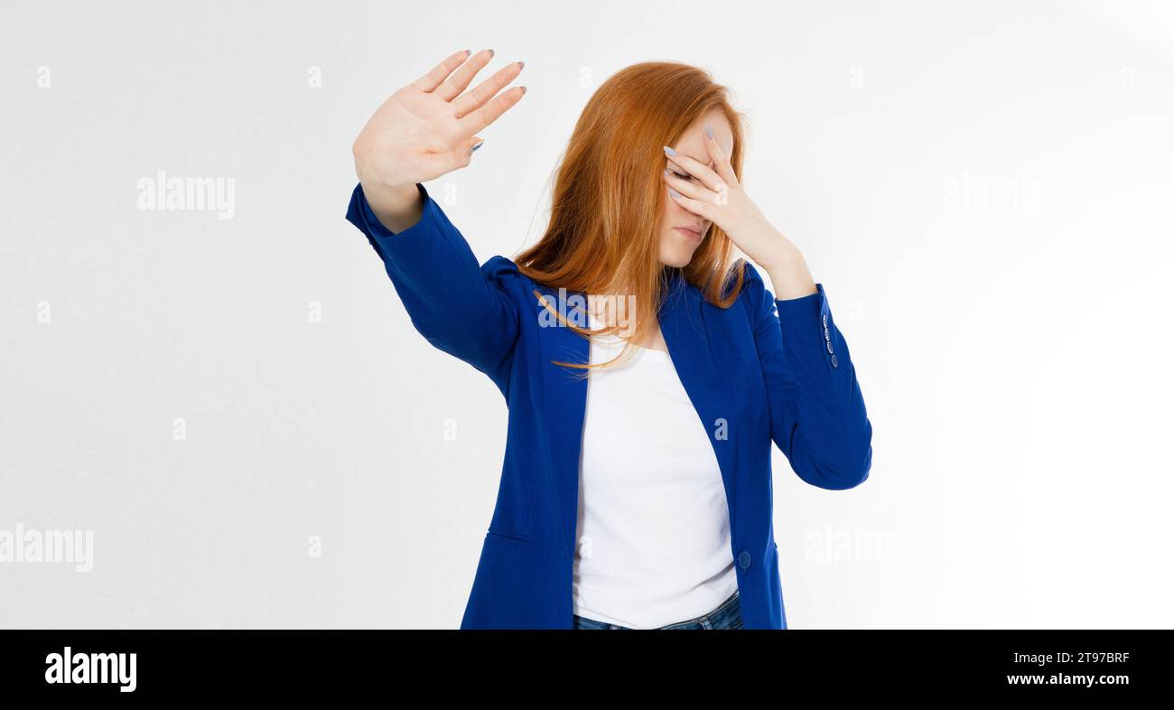 Young red hair woman making a rejection pose and facepalm on a white background. Negative human emotion face expression feeling body language Stock Photo