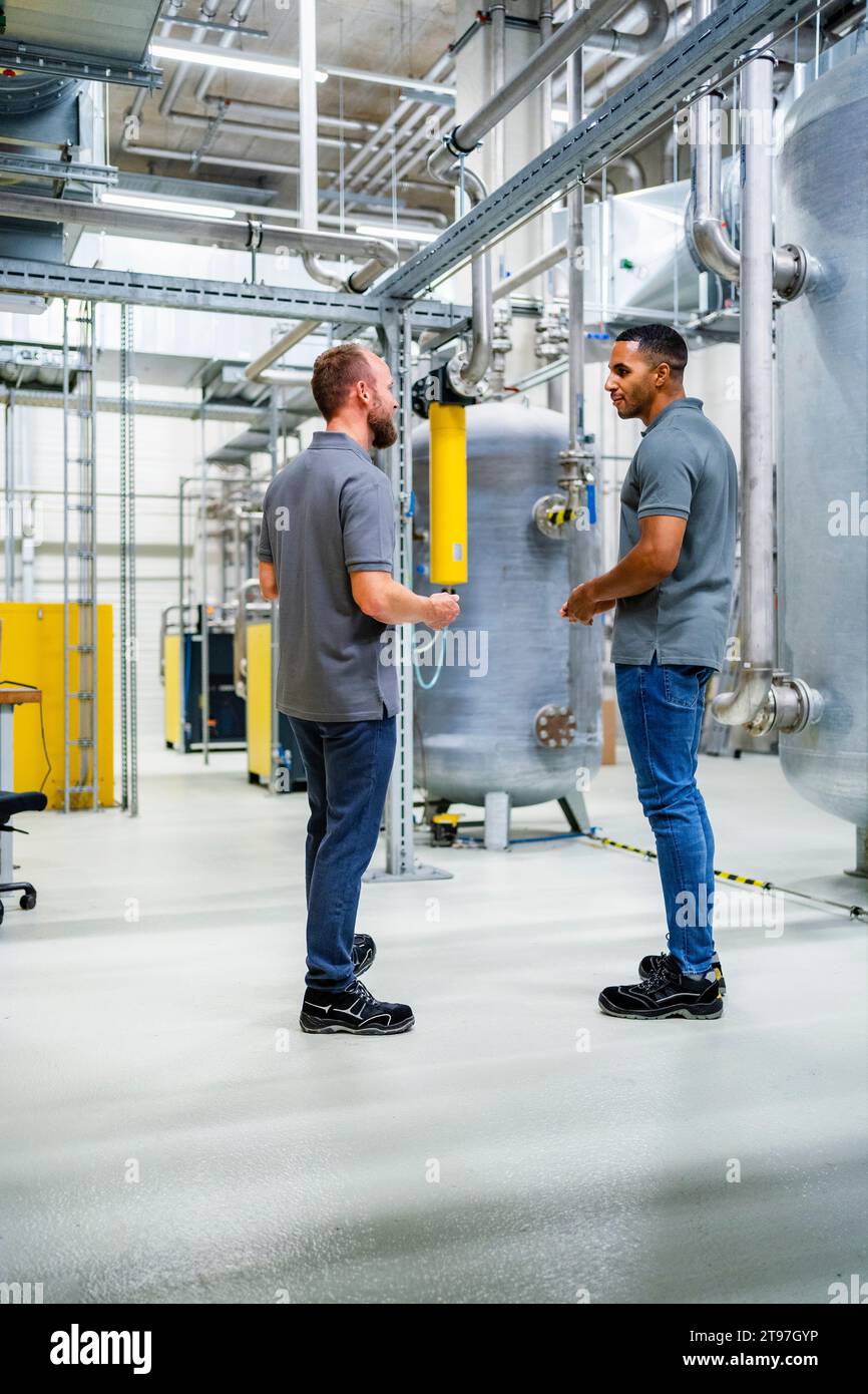 Two employees talking in factory Stock Photo