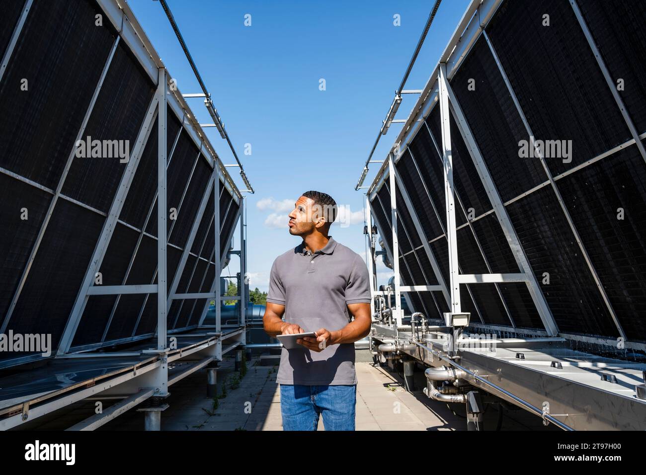 Employee with digital tablet checking refrigeration installation on rooftop Stock Photo