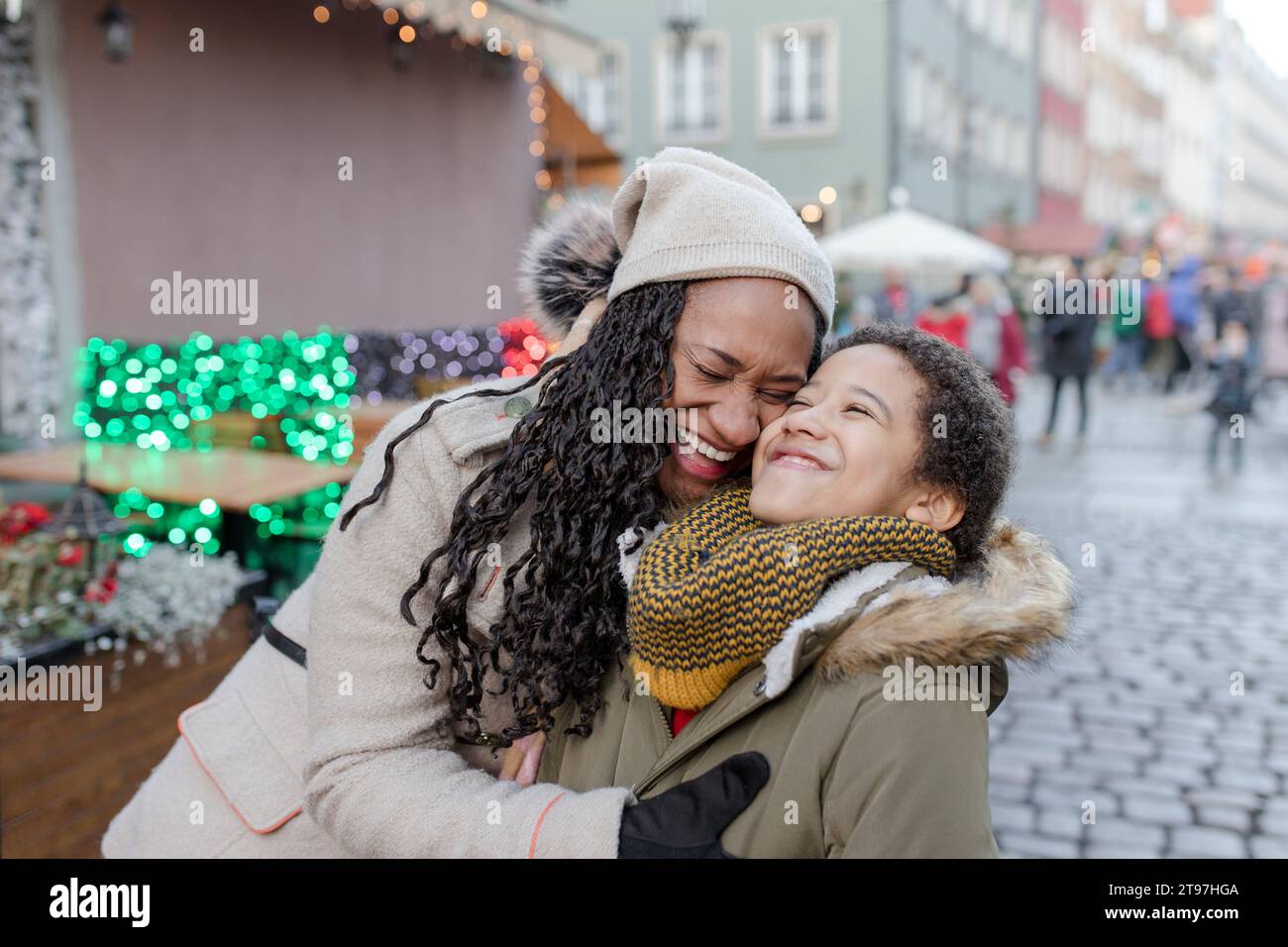 Cheerful mother hugging son at Christmas market Stock Photo