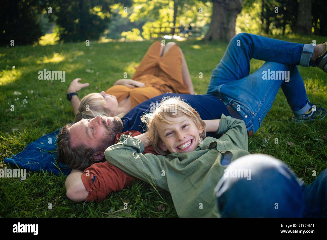 Happy boy with parents relaxing in park Stock Photo