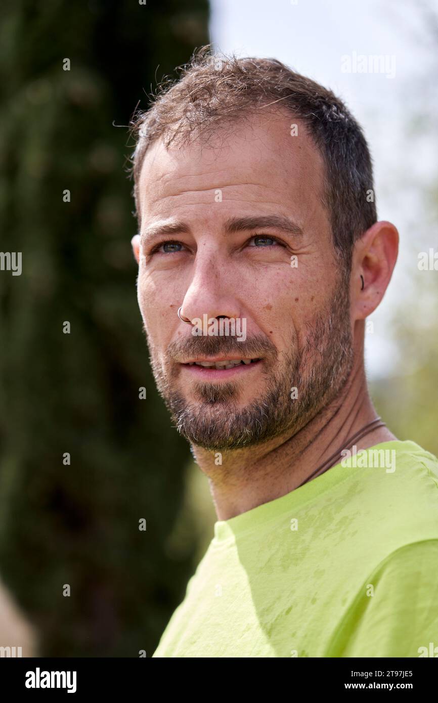 Contemplative man with hair stubble on sunny day Stock Photo