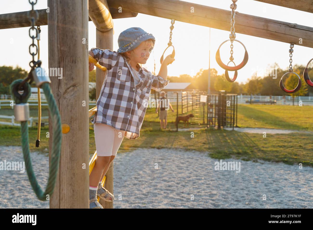Cute girl standing on playing equipment at jungle gym in playground Stock Photo