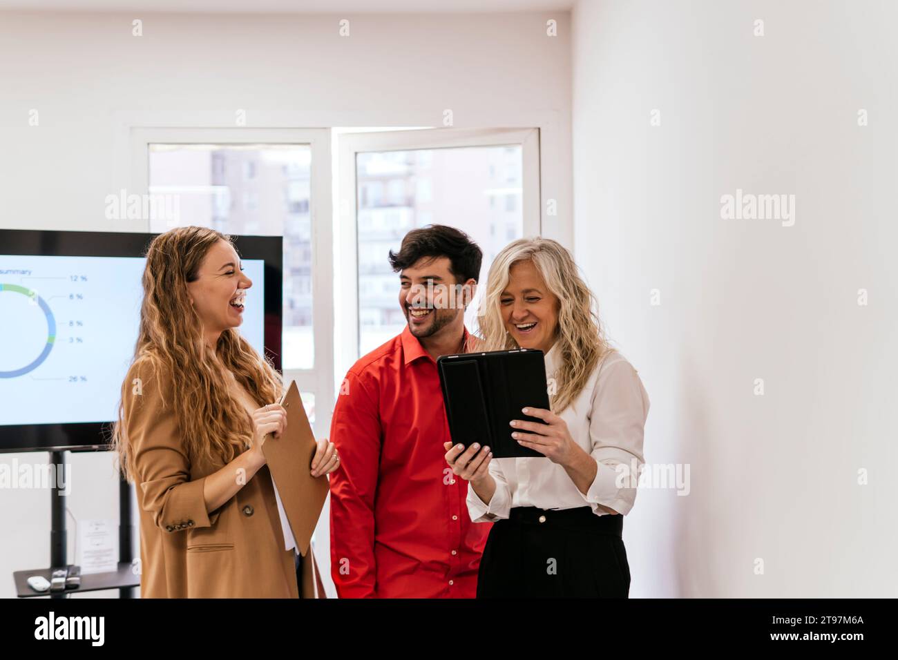 Multiracial colleagues laughing in meeting room at office Stock Photo ...