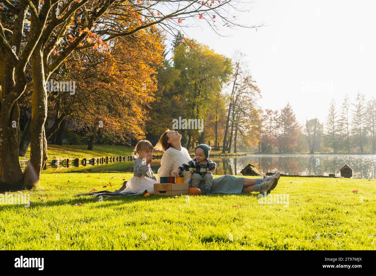 Smiling mother relaxing and spending time with children on picnic Stock Photo