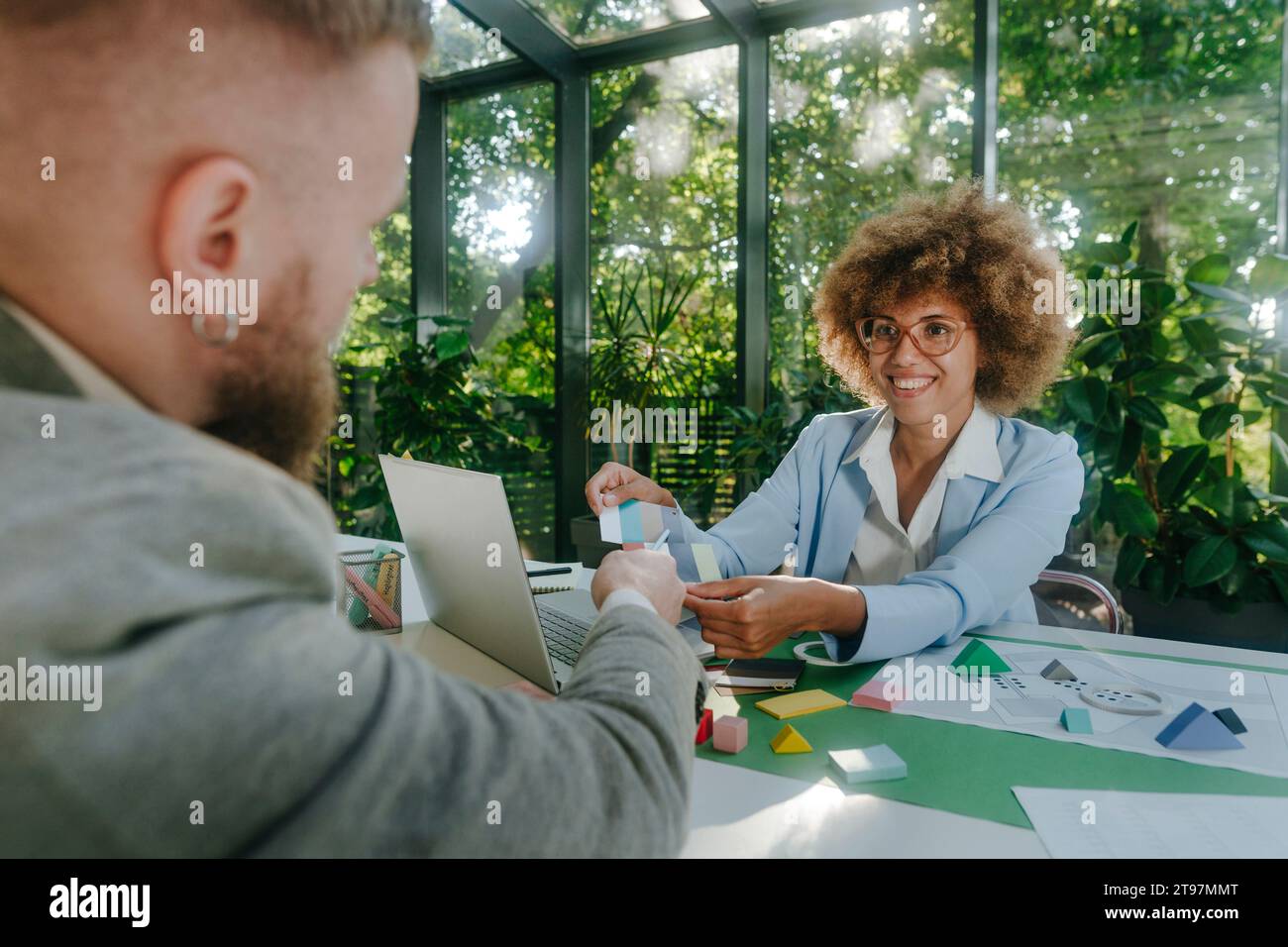 Smiling designers having discussion over color swatch in office Stock Photo