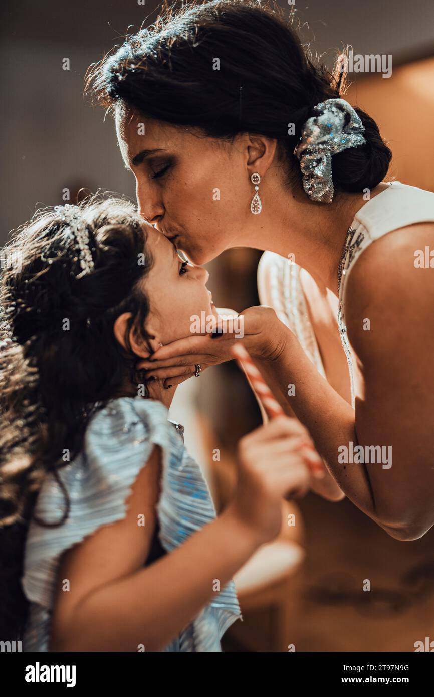 Mother kissing daughter on forehead at home Stock Photo - Alamy