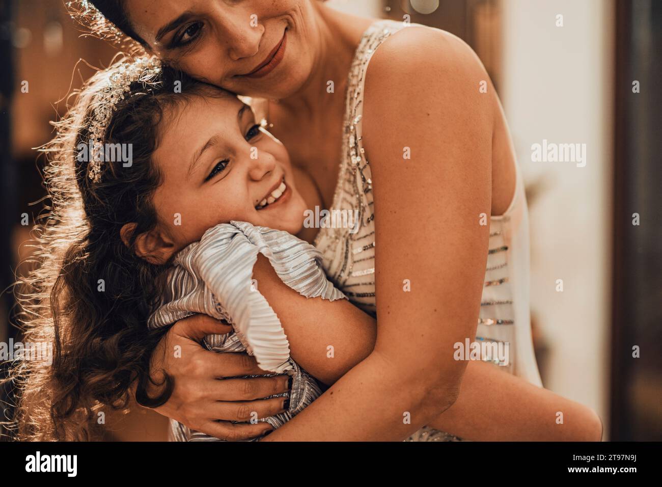 Smiling mother and daughter hugging at home Stock Photo