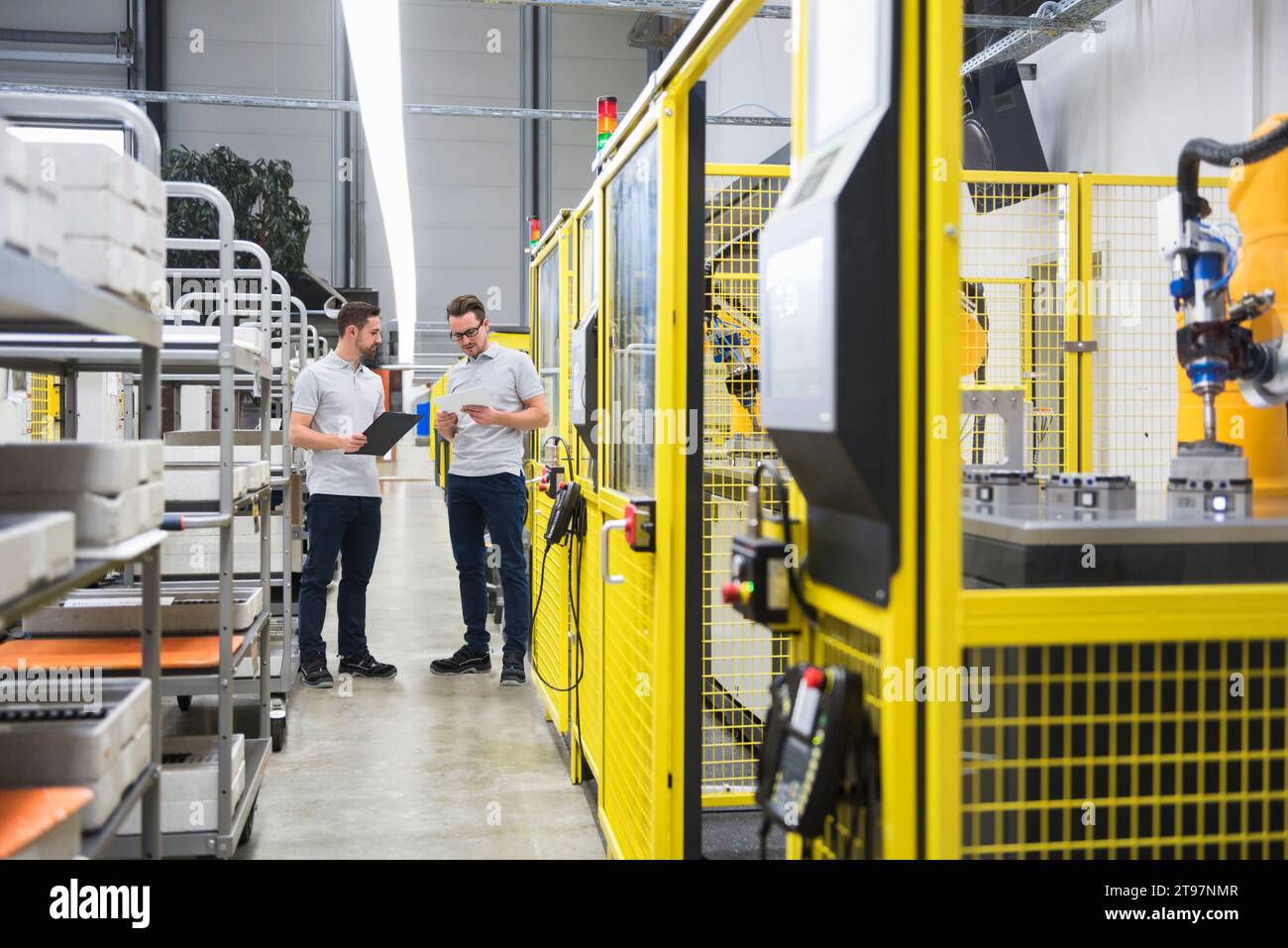 Engineers with file folder having discussion in factory Stock Photo