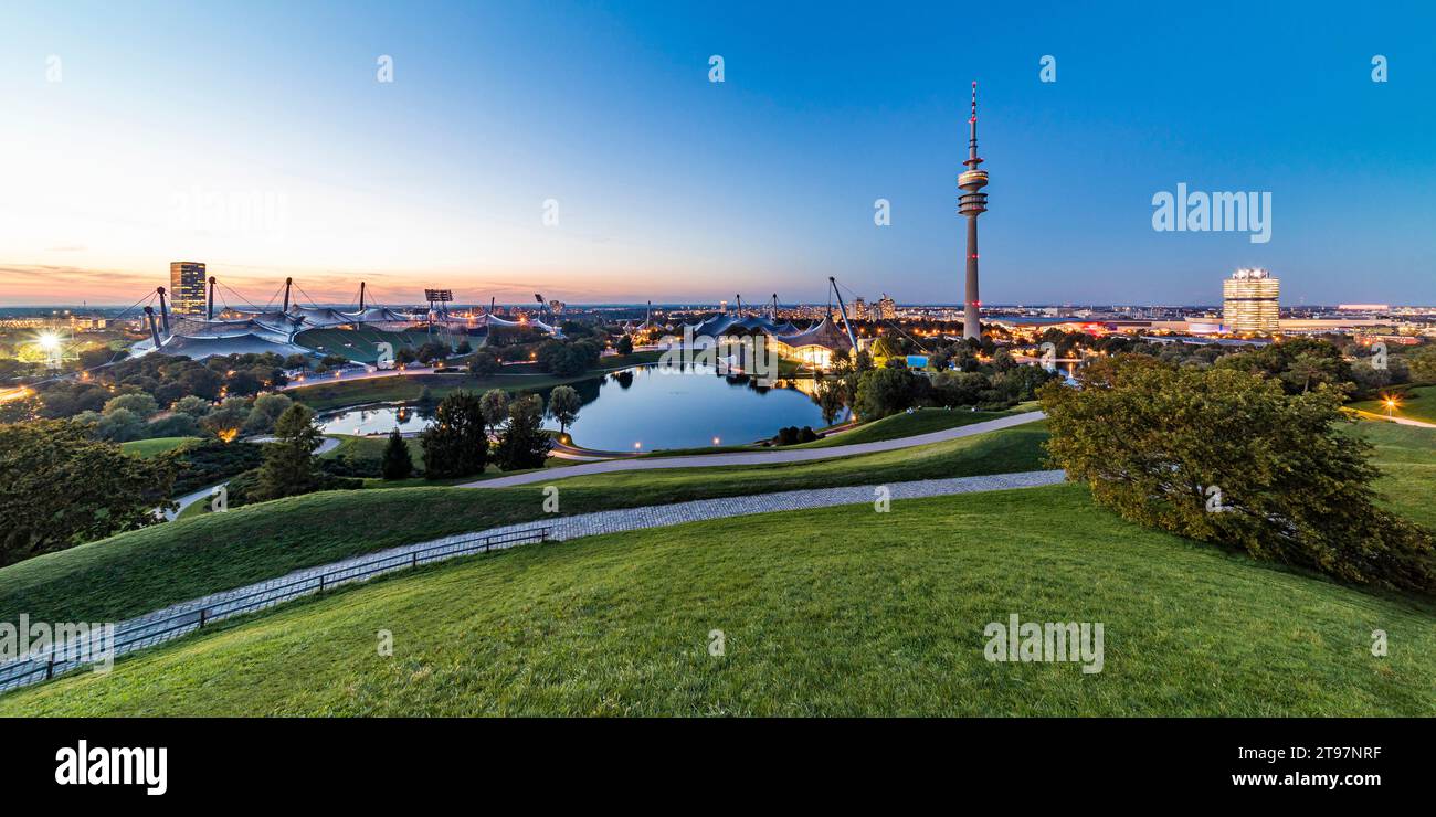 Germany, Bavaria, Munich, Panoramic view of Olympic Park with Olympic Tower, BMW Building and pond in background Stock Photo