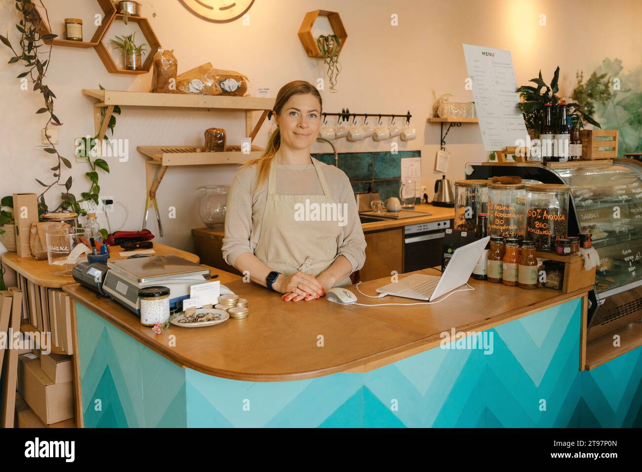 Blond owner standing at counter in cafe Stock Photo