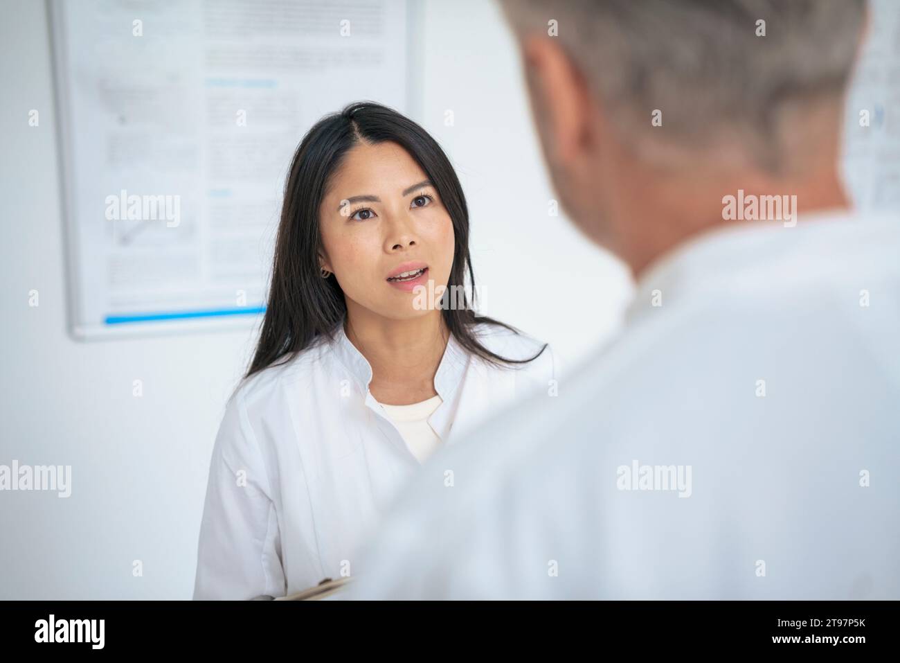 Scientist discussing with colleague in laboratory Stock Photo