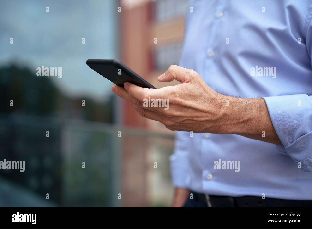 Businessman using mobile phone on balcony Stock Photo