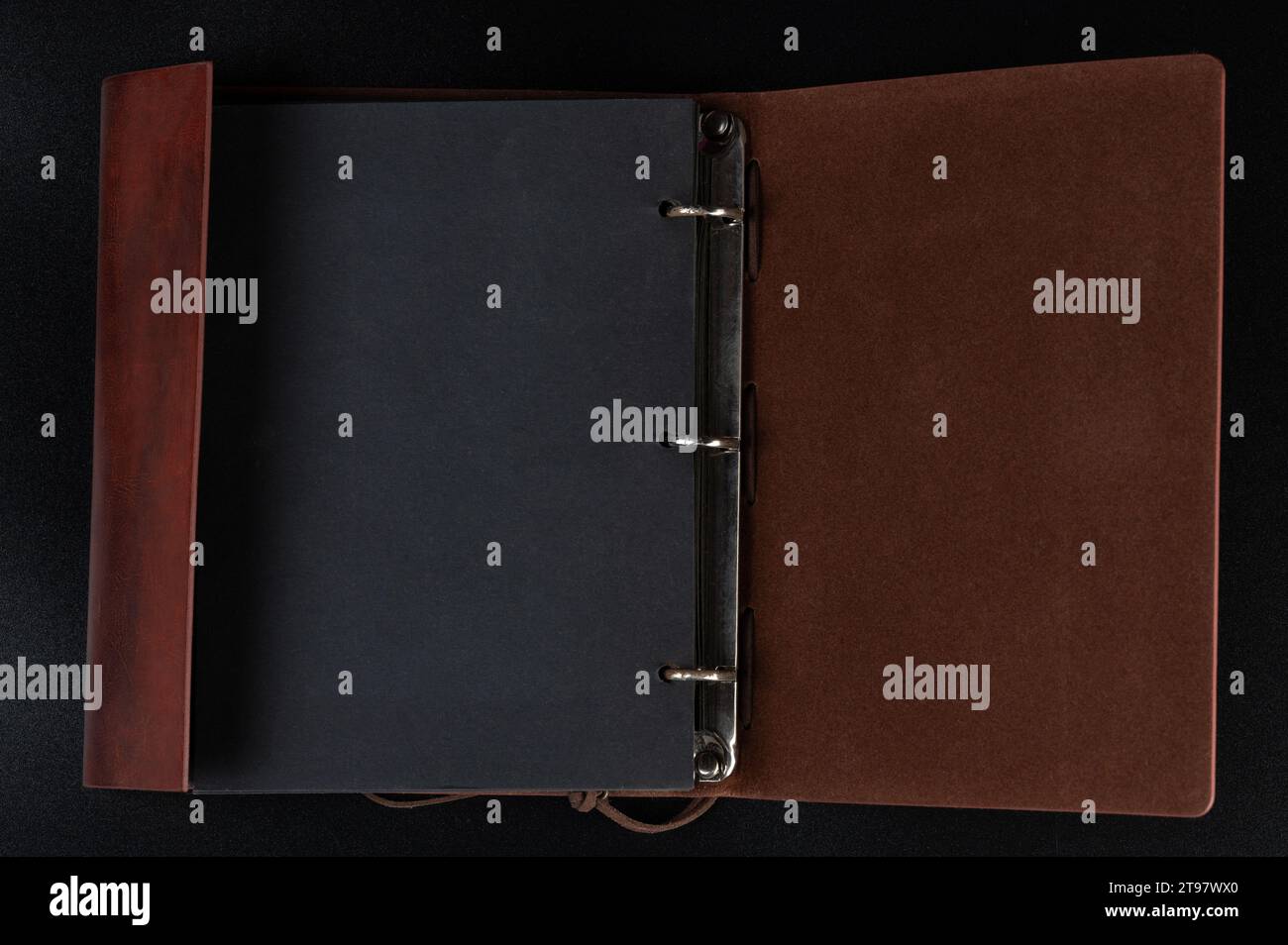 Open notebook in leather cover with black pages in binder above top view Stock Photo
