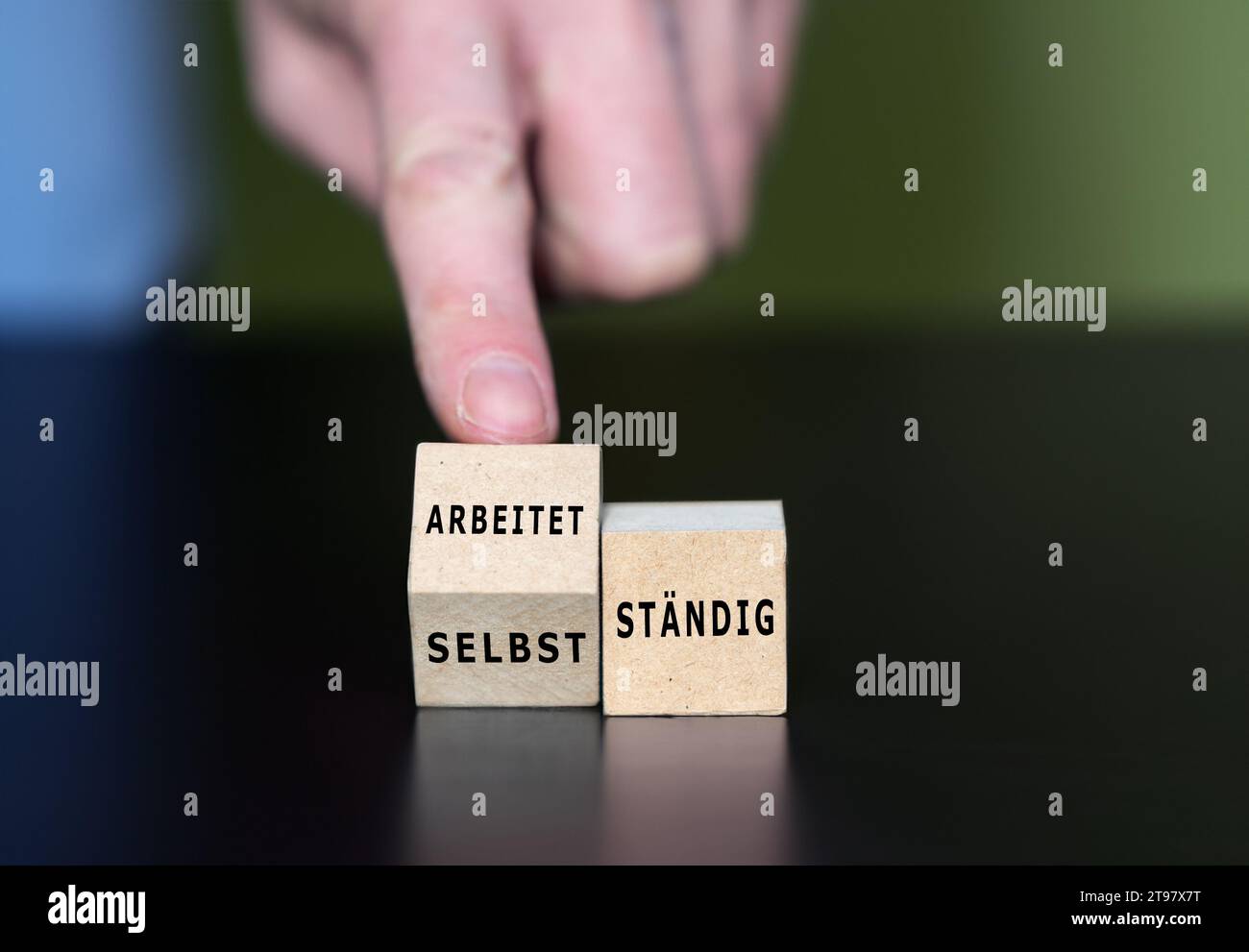 Wooden cubes form the German expressions 'selbststaendig' (self employed) and 'arbeitet staendig' (working permanently). Stock Photo