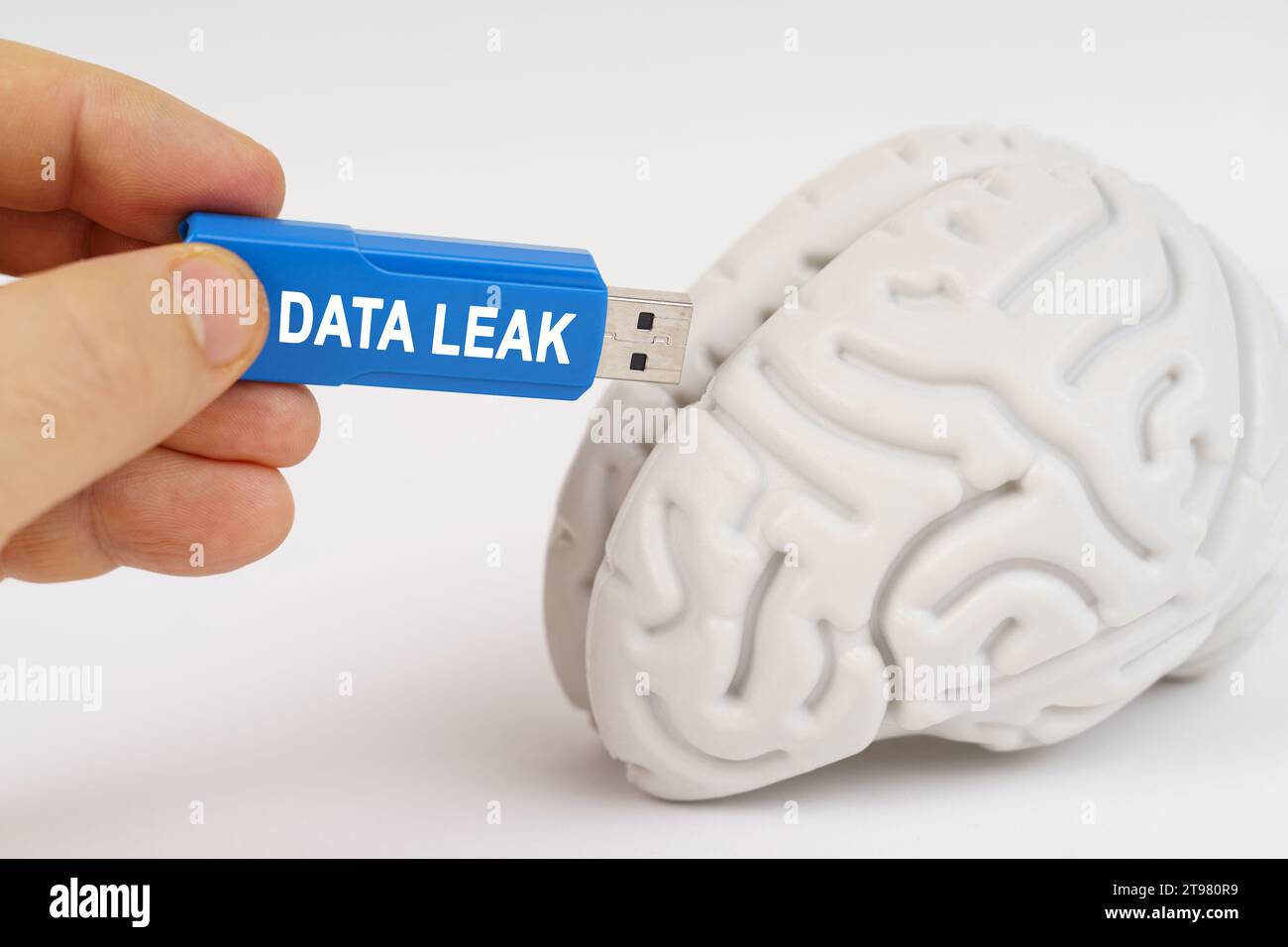 A man inserts a flash drive into his brain with the inscription - DATA LEAK. Science and technology concept. Stock Photo