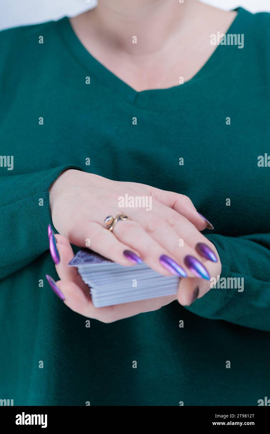 Female hands holding tarot cards for fortune telling and tricks Stock