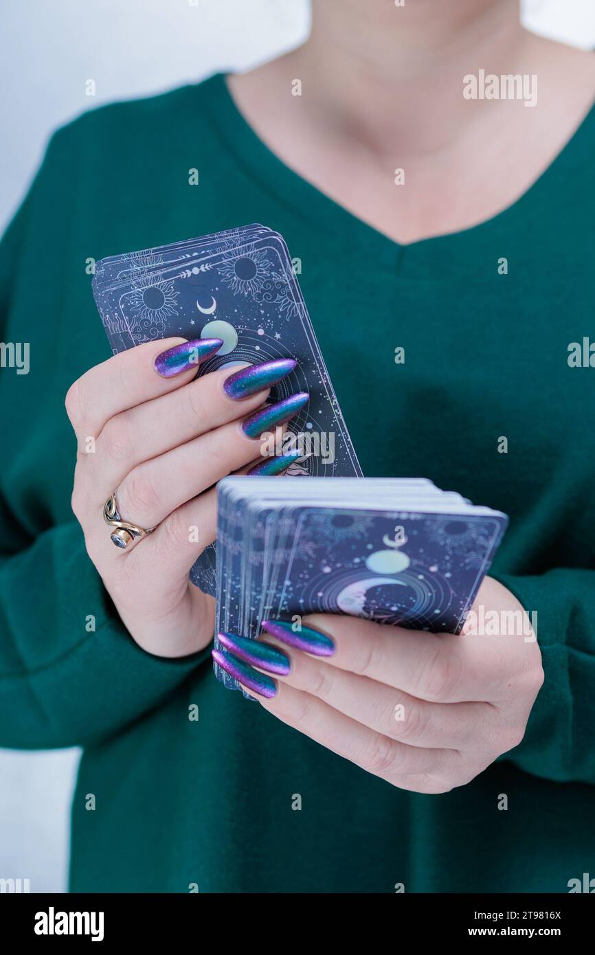 Female hands holding tarot cards for fortune telling and tricks Stock