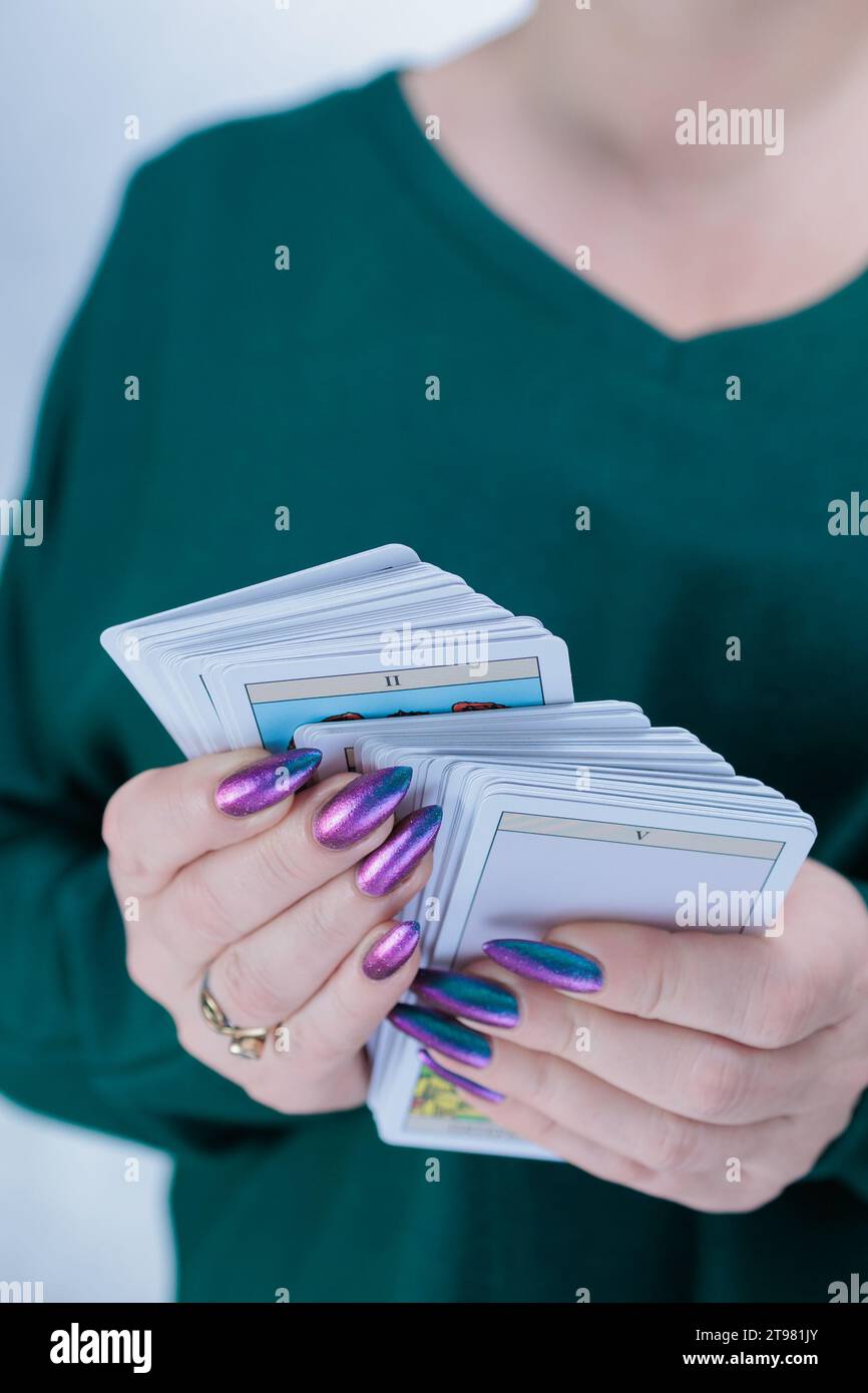 Female hands holding tarot cards for fortune telling and tricks Stock