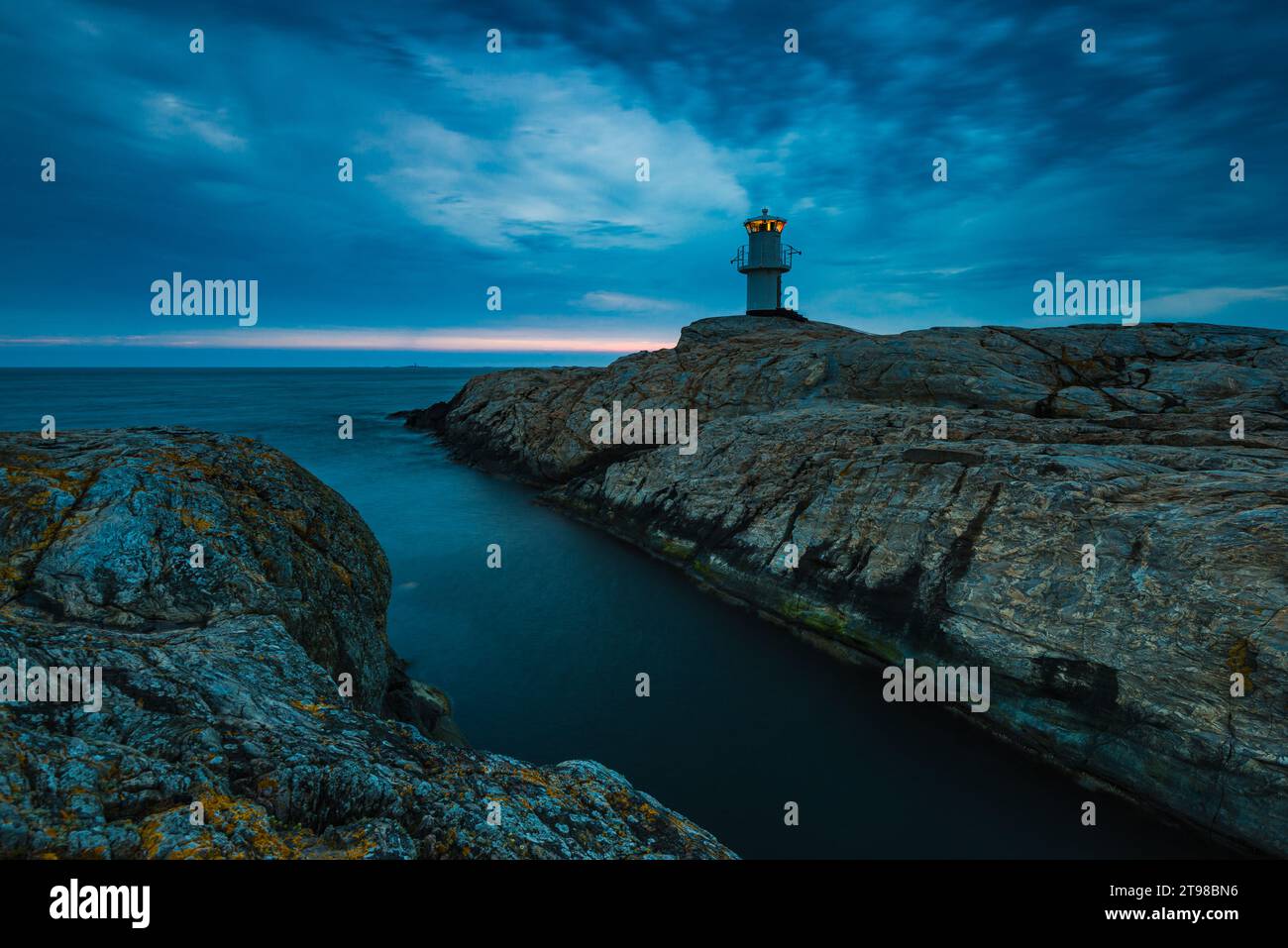 A coastal lighthouse guides night travelers towards protection and security. Stock Photo