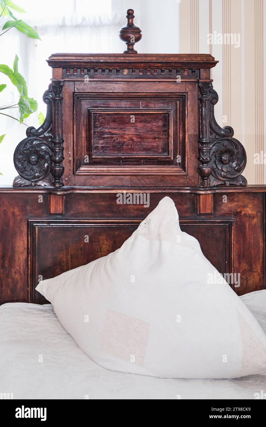 Carved headboard of an antique bed made of solid wood of valuable