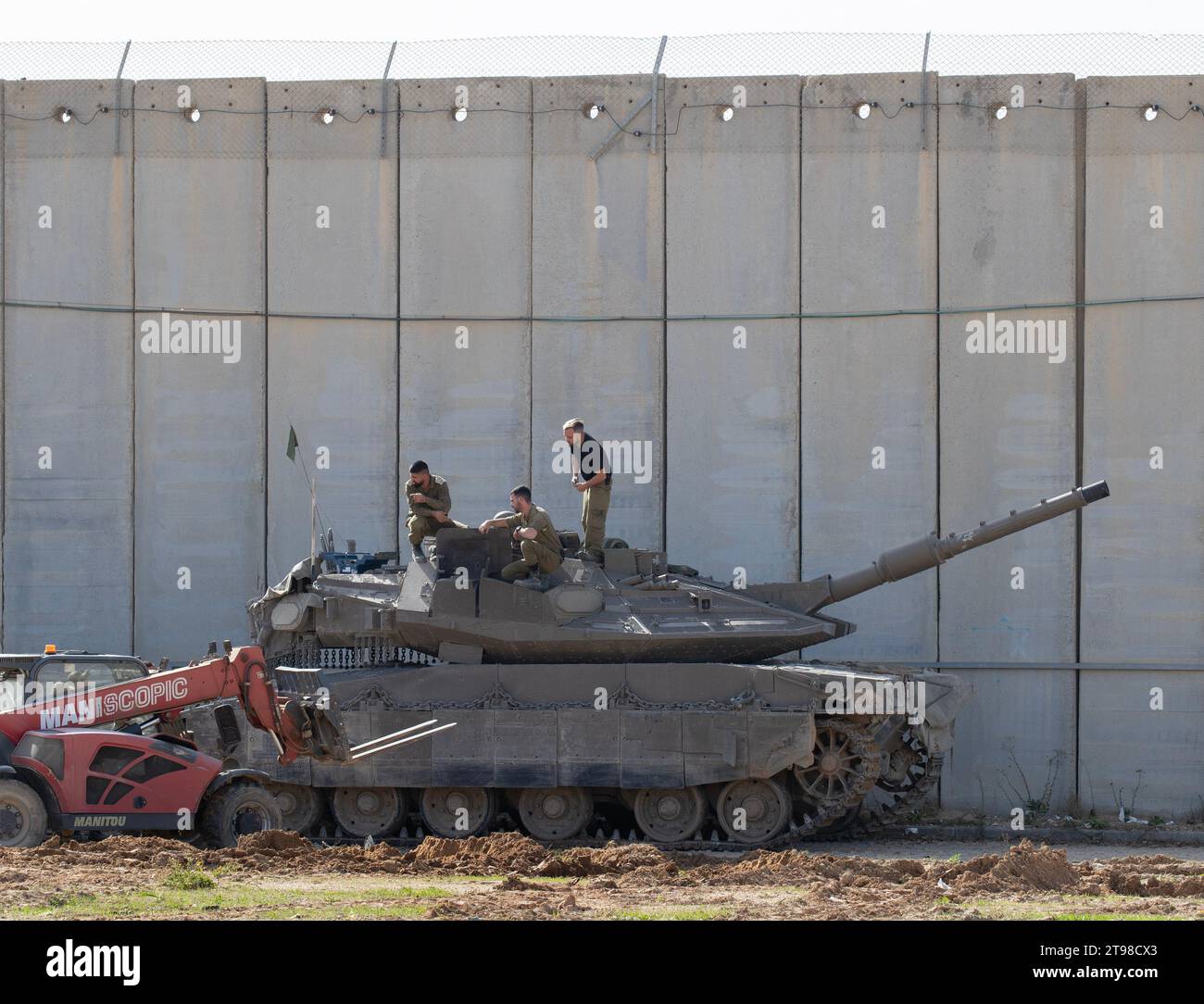 Southern Israel, Israel. 23rd Nov, 2023. Israeli soldiers work on maintenance on a Merkava tank in the shade of a cement wall separating Israel from the Gaza Strip in southern Israel on November 23, 2023. On November 24 Israel and Hamas are due to begin a ceasefire and exchange 50 Israeli hostages for 150 Palestinians prisoners held in Israel. The ceasefire is due to last five days with about 12 hostages released each day. Photo by Jim Hollander/UPI Credit: UPI/Alamy Live News Stock Photo