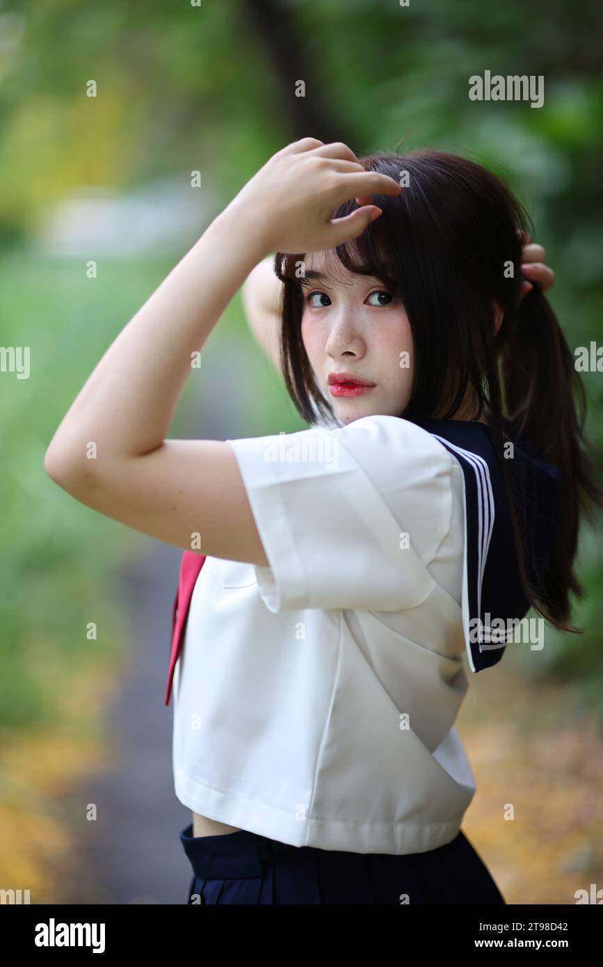 japanese girl tied Japanese high school student tied her hair up in park with tree background  Stock Photo - Alamy