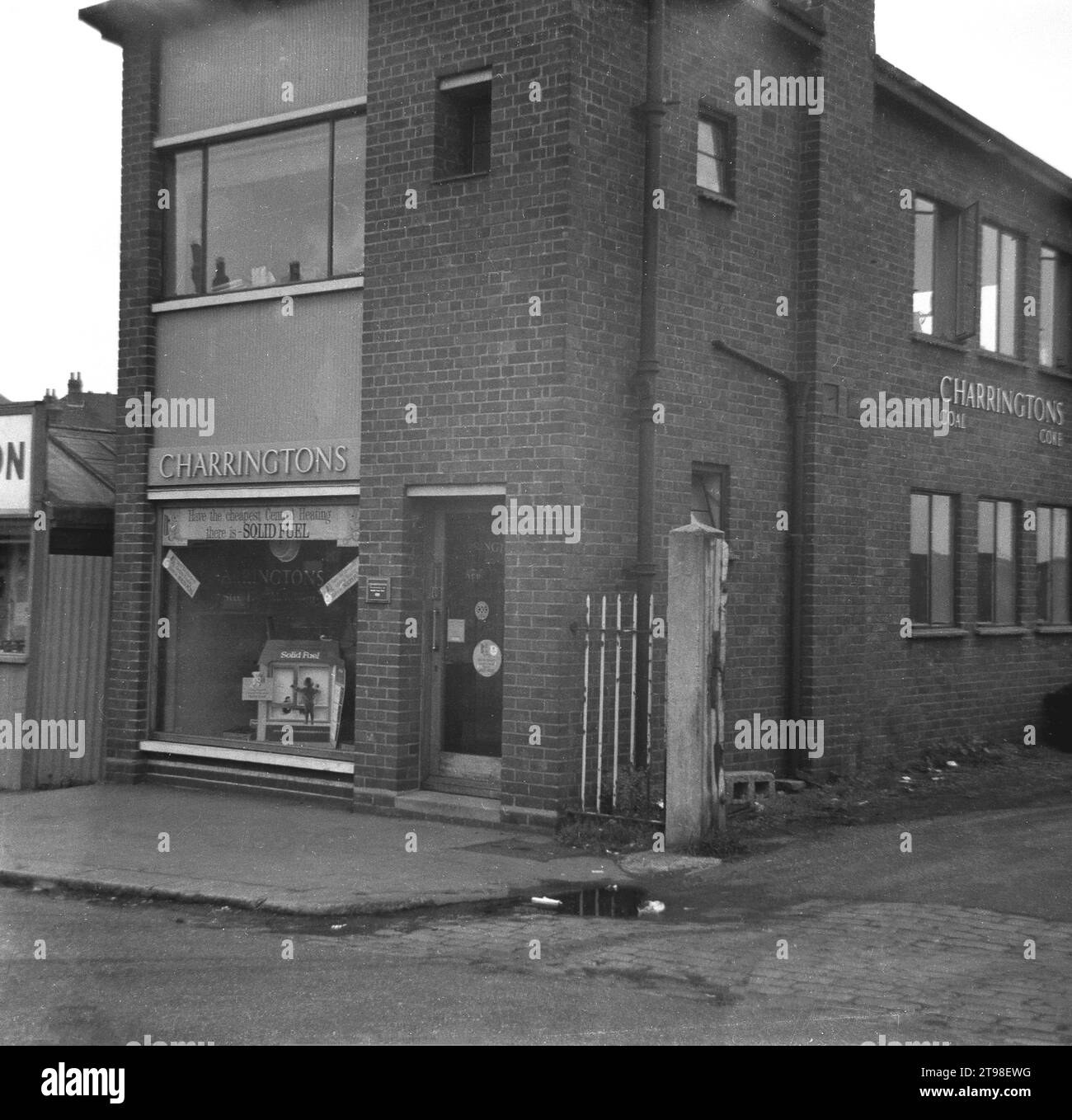 1960s, historical, exterior, offices, showroom and yard entrance of a branch of Charringtons, Coal & cok merchants, Manchester, England, UK, a business with its roots dating back to 1731. The front wIndow promotes 'Solid Fuel' as the cheapest central heating available. In this era, coal was an important fuel for heating peoples homes. Stock Photo
