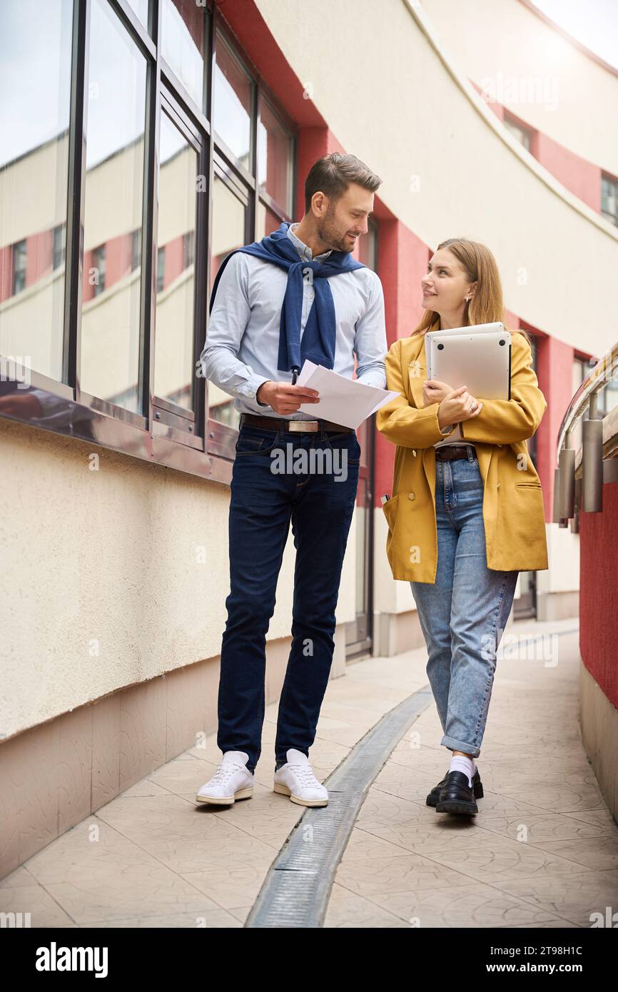 Colleagues review work documents on a large balcony Stock Photo