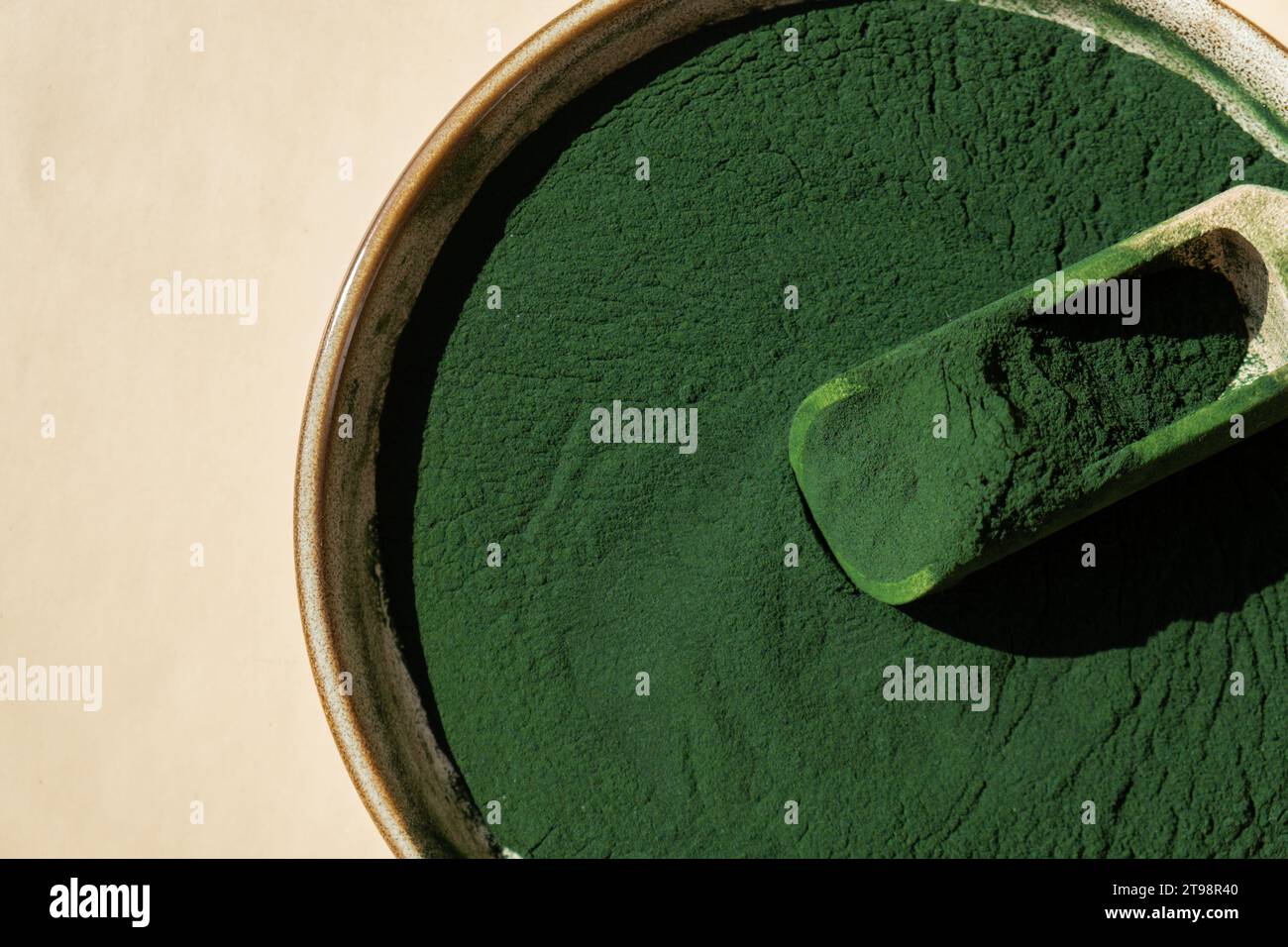 Organic blue-green algae spirulina powder food in plate with wooden ...