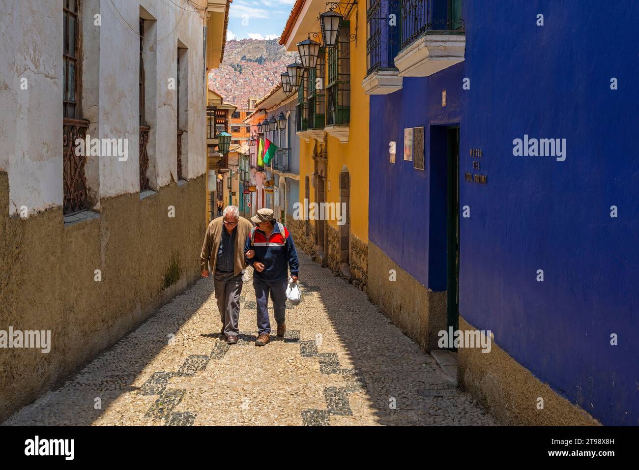 Two senior bolivian men walking in colonial style street of La Paz, Bolivia. Stock Photo